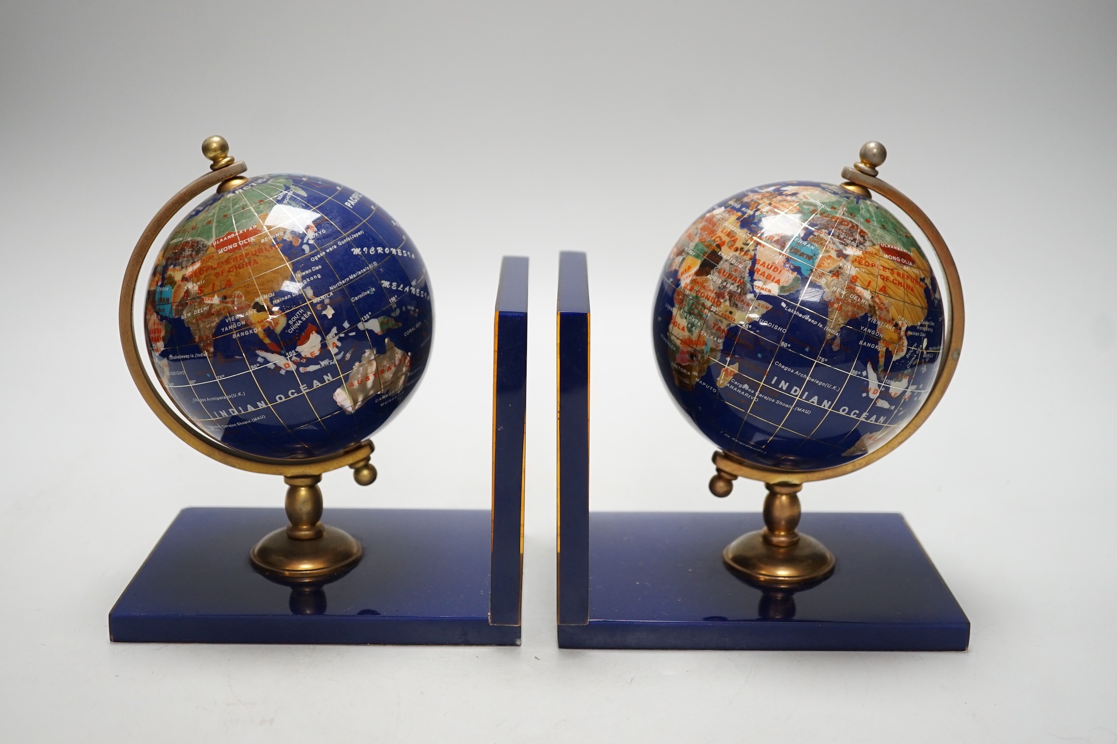 A pair of hardstone mounted acrylic ‘terrestrial globe’ bookends. 18cm tall